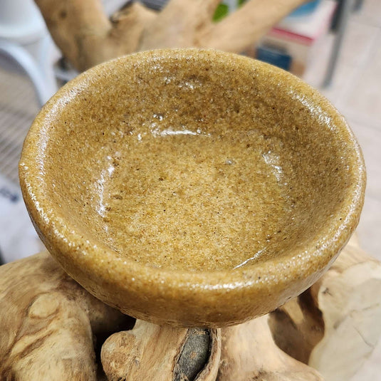 Brown ceramic bowl on a natural wood and stone background